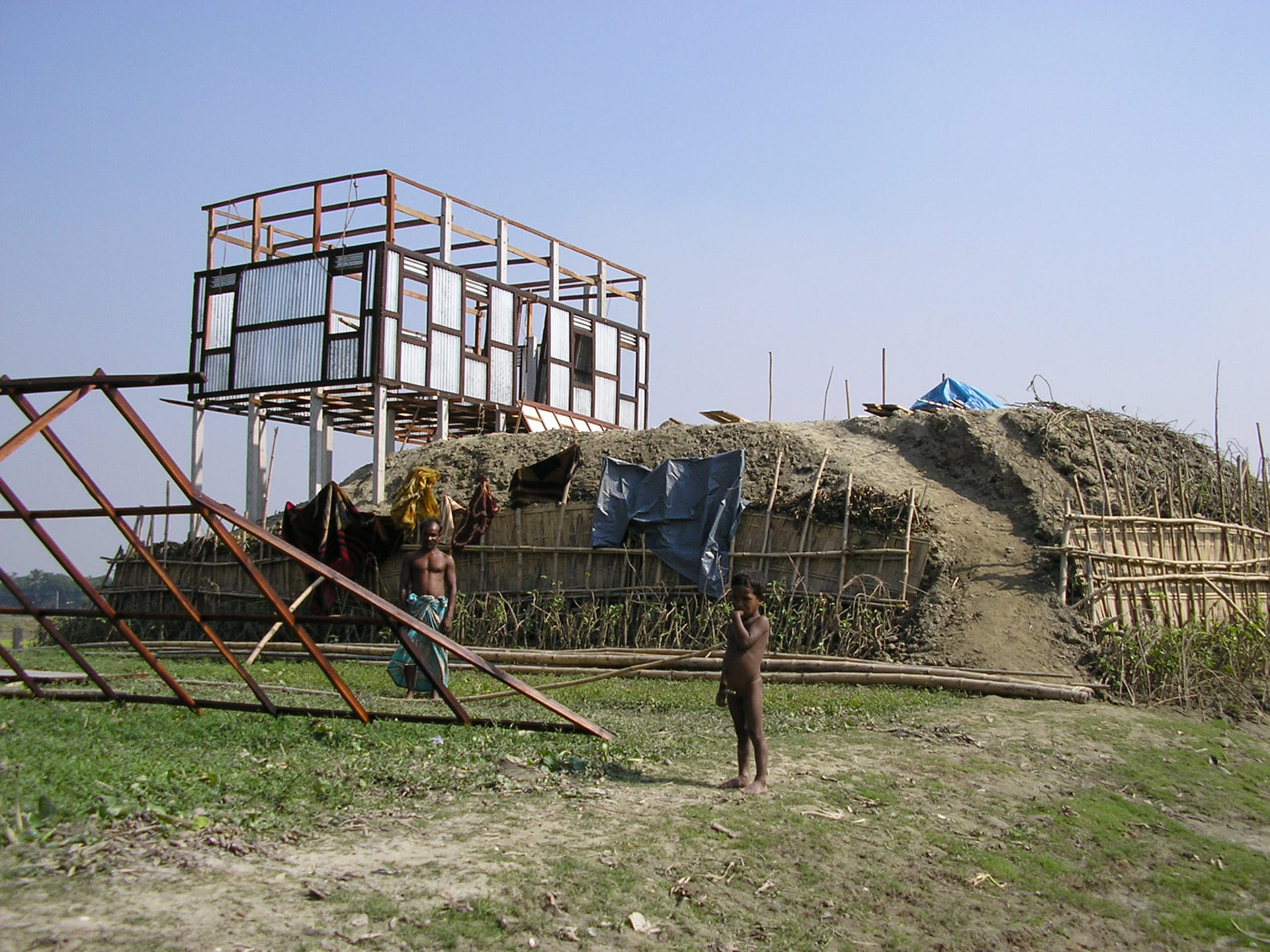 House being built on stilts on an earthen mound in Bangladesh