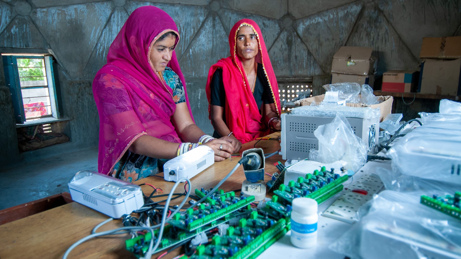 Rural women making electric circuit to bring electricity from solar energy to the village 