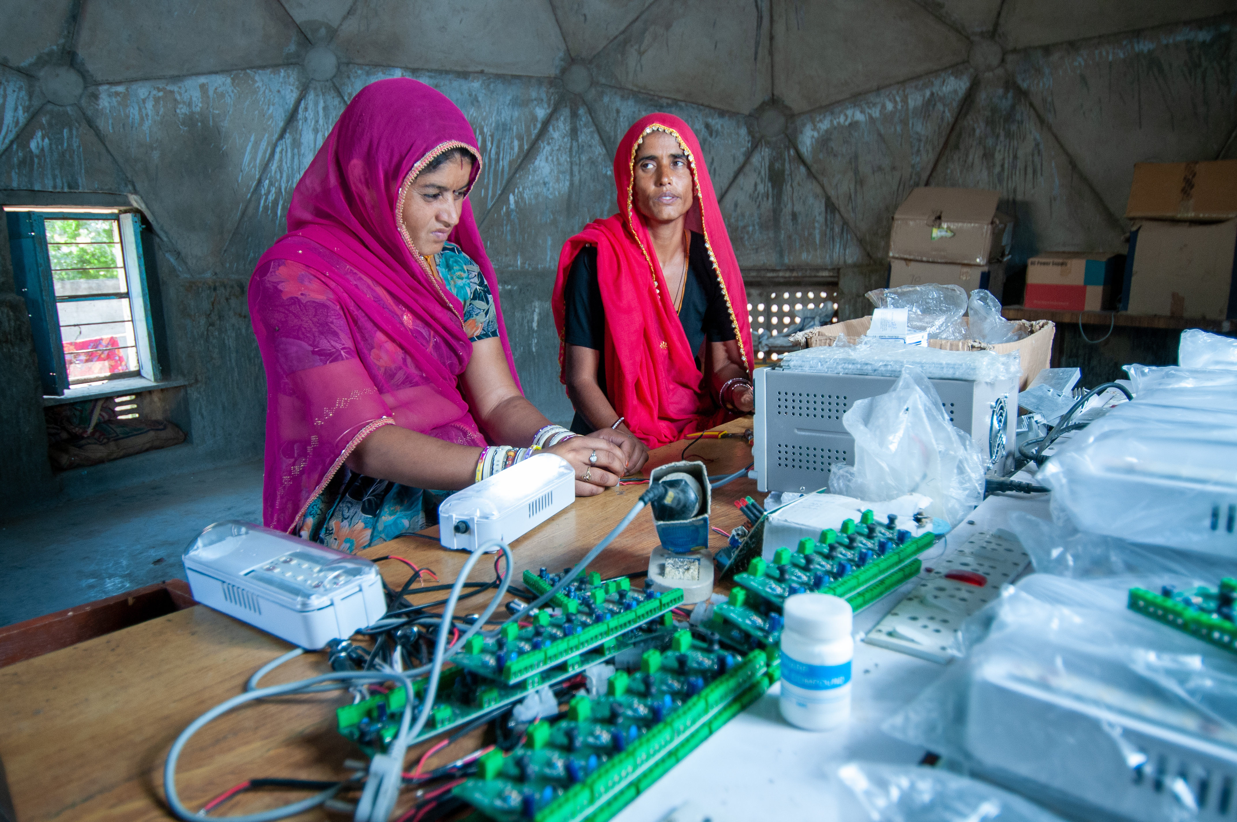 Rural women making electric circuit to bring electricity from solar energy to the village